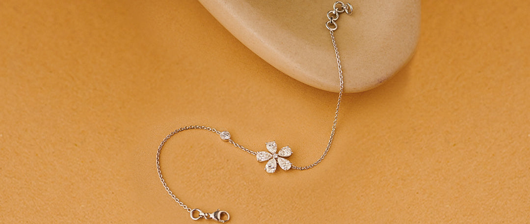Delicate silver bracelet with a floral design on a beige background