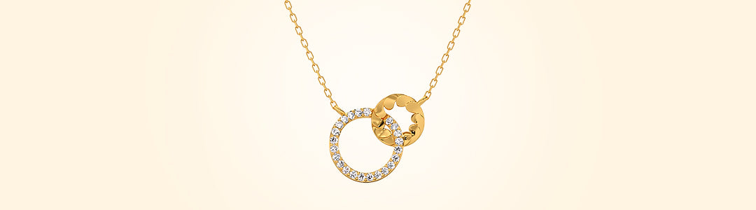 Gold necklace with interlocking rings on a beige background