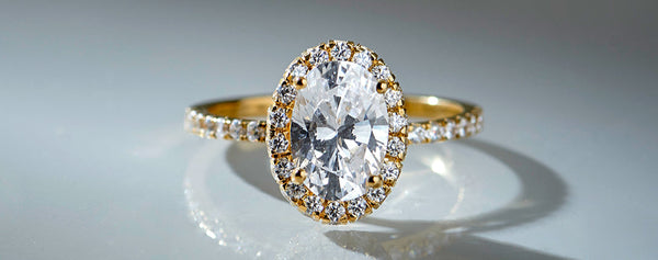 Gold ring with a large diamond on a reflective surface