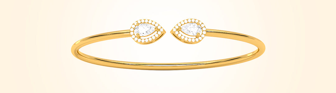 Gold bracelet with eye-shaped charms on a beige background
