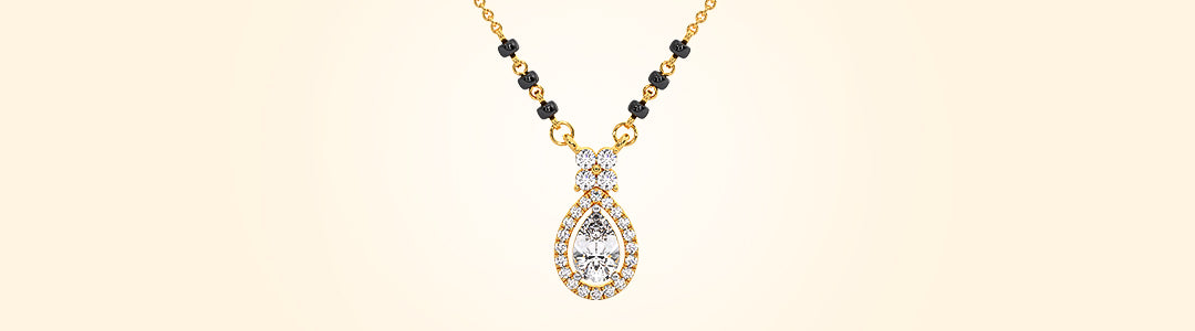 Gold necklace with a teardrop-shaped pendant on a beige background