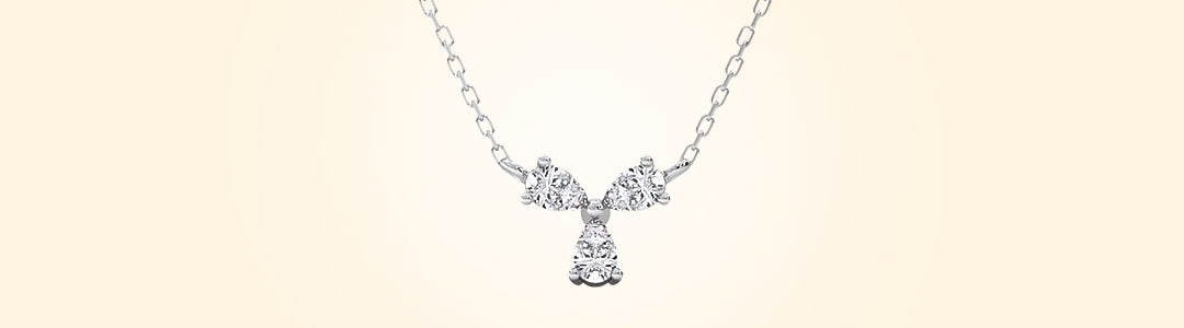 Silver necklace with a bow-shaped pendant on a beige background